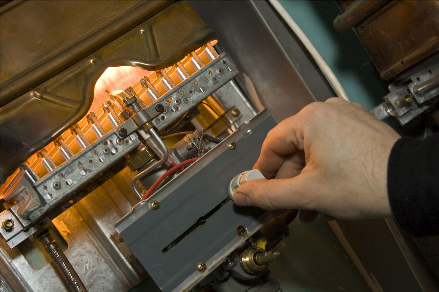 a close up of a man’s hand servicing a domestic boiler